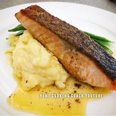 A picture of Crispy skin Salmon with mash, greens and lemon butter sauce.