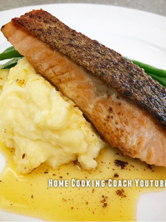 A picture of Crispy skin Salmon with mash, greens and lemon butter sauce.