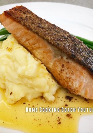 A picture of Crispy skin Salmon with mash, greens and lemon butter sauce.