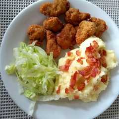 Una foto de Nuggets de pollo con puré de papá y ensalada