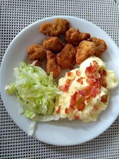 Una foto de Nuggets de pollo con puré de papá y ensalada