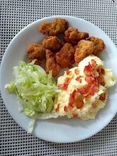 Una foto de Nuggets de pollo con puré de papá y ensalada