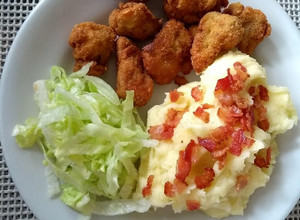 Una foto de Nuggets de pollo con puré de papá y ensalada
