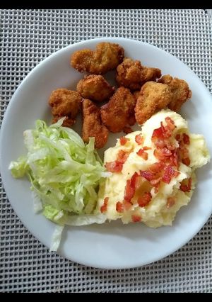 Una foto de Nuggets de pollo con puré de papá y ensalada