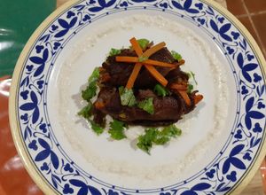 Una foto de Rollitos de carne con verduras acompañado de un puré de elote