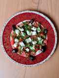Ensalada de queso Brie, albahaca, tomates cherry y olivas negras