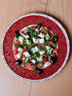 Una foto de Ensalada de queso Brie, albahaca, tomates cherry y olivas negras