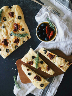 Una foto de Foccacia con tomates secos, aceitunas negras y romero