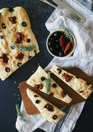 Una foto de Foccacia con tomates secos, aceitunas negras y romero