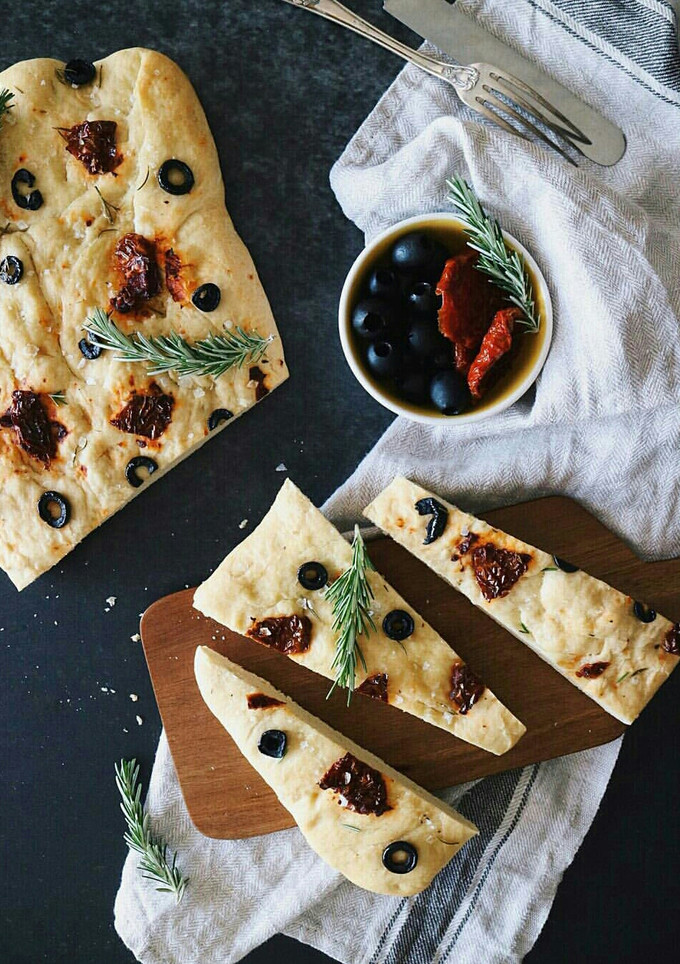 Una foto de Foccacia con tomates secos, aceitunas negras y romero