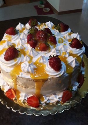 Una foto de Torta rellena de pastelera y compota de piña con fresas picadas