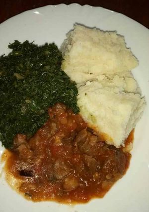 A picture of Wet fried beef, kales and ugali.