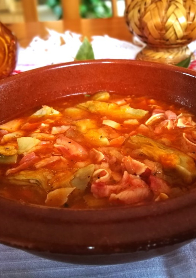 Una foto de Oreja de cerdo con salsa de tomate con alcachofas