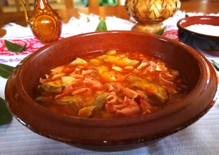 Oreja de cerdo con salsa de tomate con alcachofas