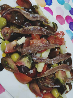 Una foto de Ensalada de tomates raff y anchoas