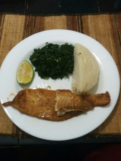 A picture of Grilled fish fillets with steamed kales and ugali.