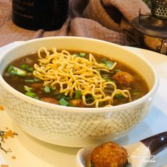 A picture of Whosayna’s Chicken Manchow Soup topped with Manchurian balls.