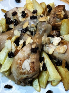 Una foto de Muslos de pollo estofados con almendras, arándanos y pasas