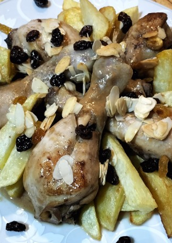 Una foto de Muslos de pollo estofados con almendras, arándanos y pasas