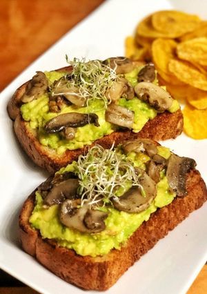 Una foto de Pan artesanal con aguacate y champiñones