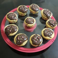 A picture of Vanilla cup cakes with chocolate frosting.