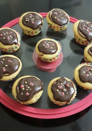 A picture of Vanilla cup cakes with chocolate frosting.