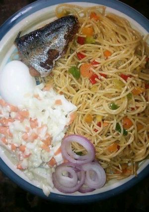 A picture of Spagetti wirh coleslaw and boiled egg.