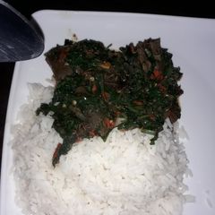 A picture of White rice with ugu sauce.