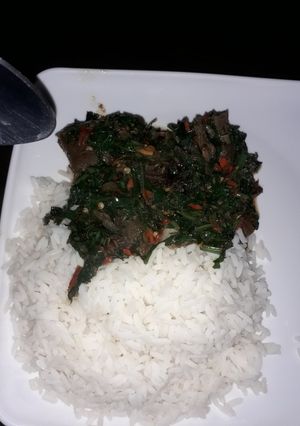 A picture of White rice with ugu sauce.