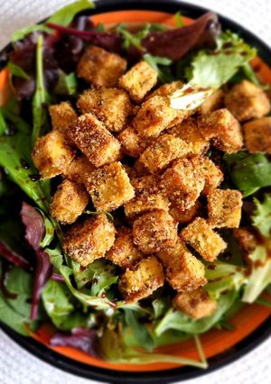 O poză a rețetei Crispy tofu în fulgi de quinoa cu mix de salată și oțet balsamic.