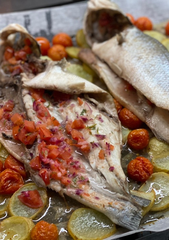 Una foto de Lubina al horno con picadillo de tomate