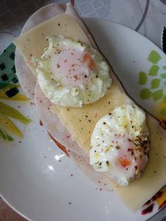 Una foto de Tostada con pechuga de pavo, queso y huevo poché