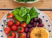 Una foto de ensalada de tomate y aceitunas