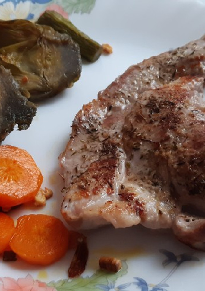 Una foto de Chuletas de cerdo deshuesadas con alcachofas y zanahoria