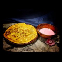A picture of Paneer paratha with strawberry yogurt.