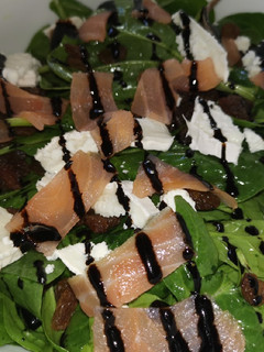 Una foto de Ensalada de espinacas con salmón ahumado, queso de cabra y pasas