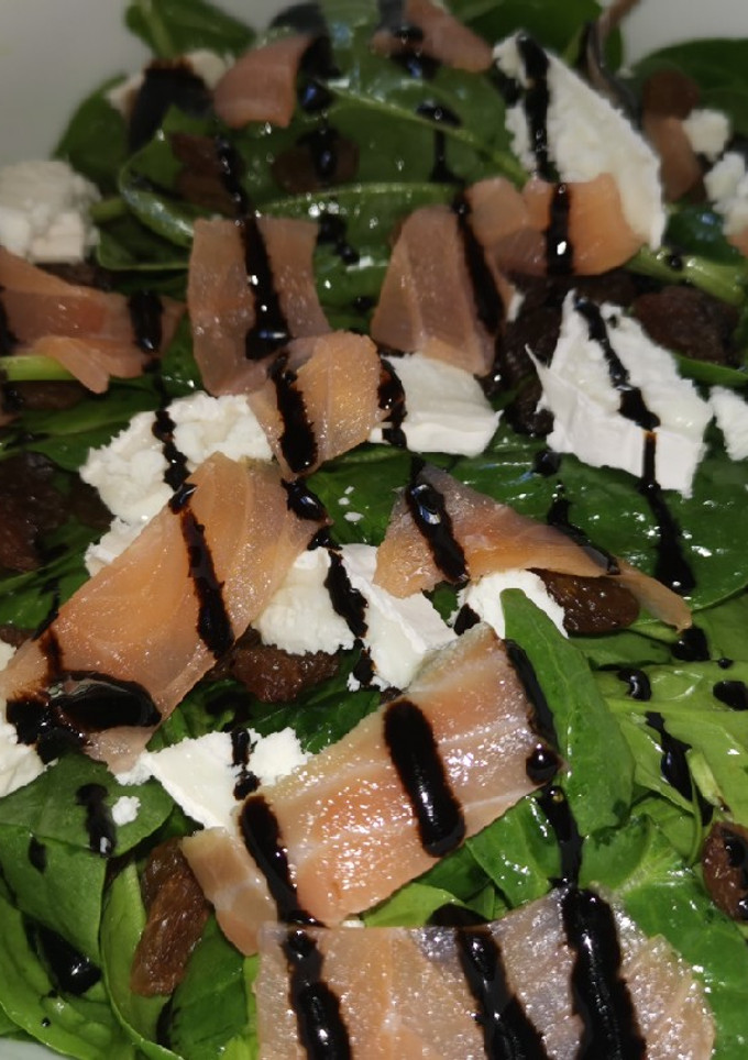 Una foto de Ensalada de espinacas con salmón ahumado, queso de cabra y pasas