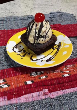 Una foto de Brownie con helado y baño de chocolate