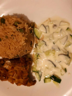 A picture of Rice served with coated chicken and sauce.