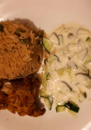 A picture of Rice served with coated chicken and sauce.