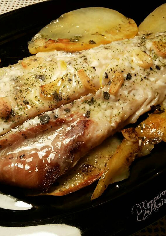 Una foto de Merluza del pincho al horno, con patatas y ajos