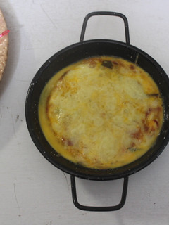 Una foto de Sartenes individuales con verduras cocidas y huevos rotos