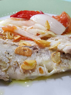 Una foto de Besugo al horno con cebolla y tomate