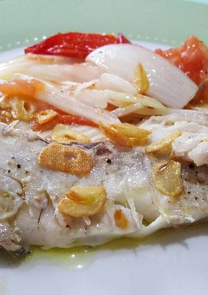 Una foto de Besugo al horno con cebolla y tomate