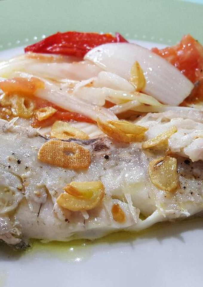 Una foto de Besugo al horno con cebolla y tomate