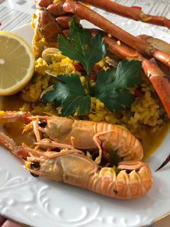 Una foto de Arroz con cuerpos de centollo o cangrejo, cigalas, almejas y calamar