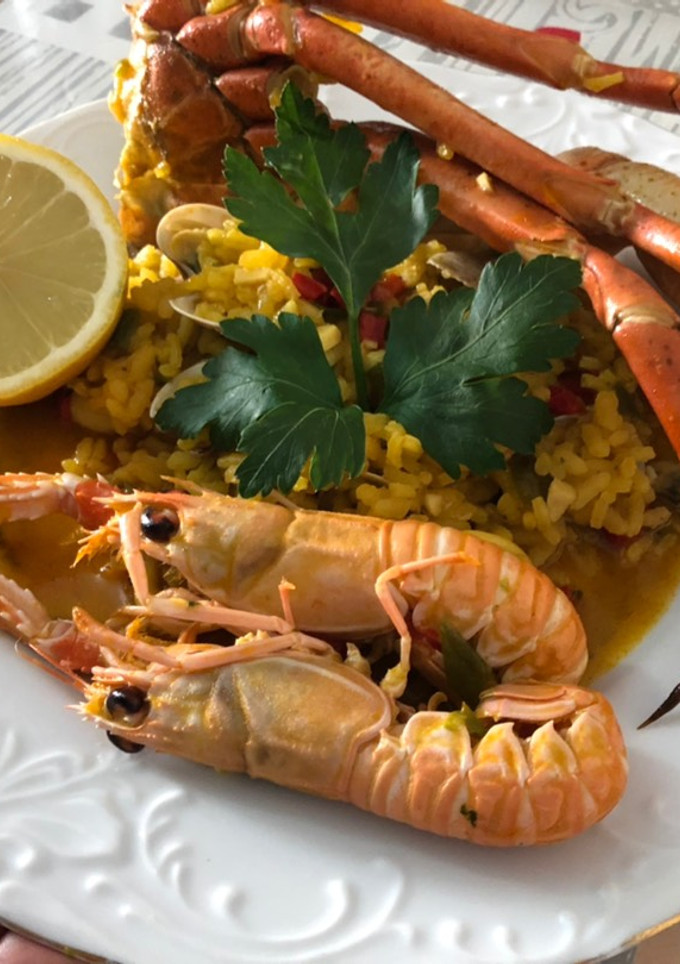 Una foto de Arroz con cuerpos de centollo o cangrejo, cigalas, almejas y calamar