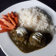 A picture of Baked chickpea balls in spinach gravy.