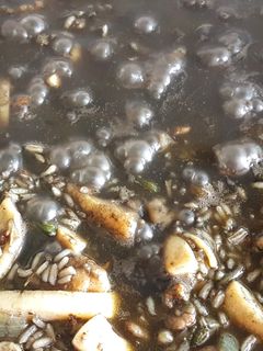 Una foto de Arroz negro con calamar y gambas