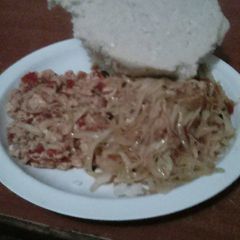 A picture of Fried eggs served with fried cabbage and ugali.